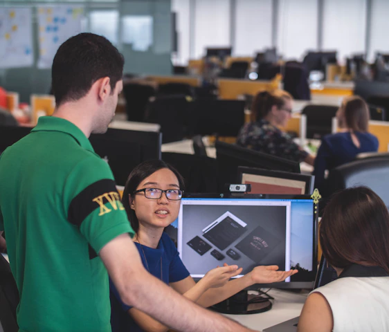 A collaborative team of engineers and designers reviewing product prototypes in a modern offshore manufacturing facility.