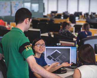 A collaborative team of engineers and designers reviewing product prototypes in a modern offshore manufacturing facility.