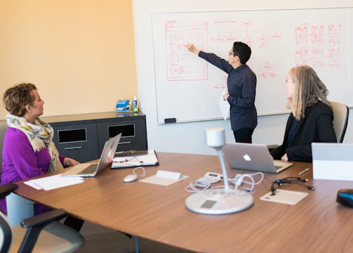Project managers reviewing schedules and progress charts in a meeting.